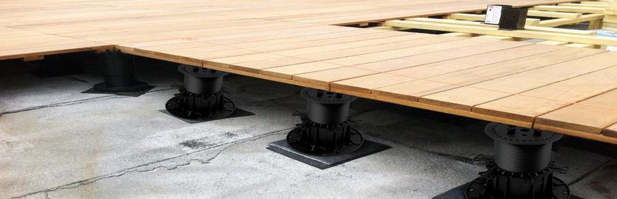 Pedestal installation under a wood-tile floor on a construction site