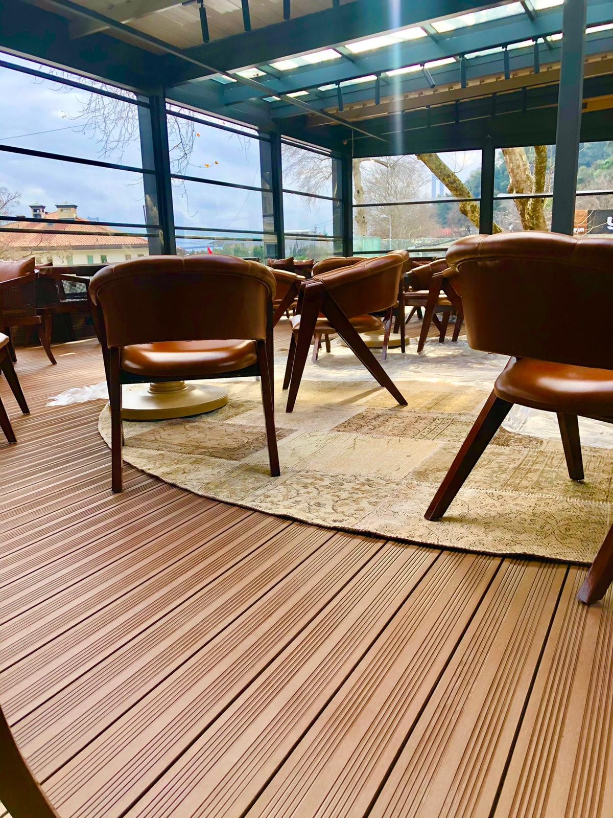 Glass-fronted café terrace finished with Classic Line composite decking